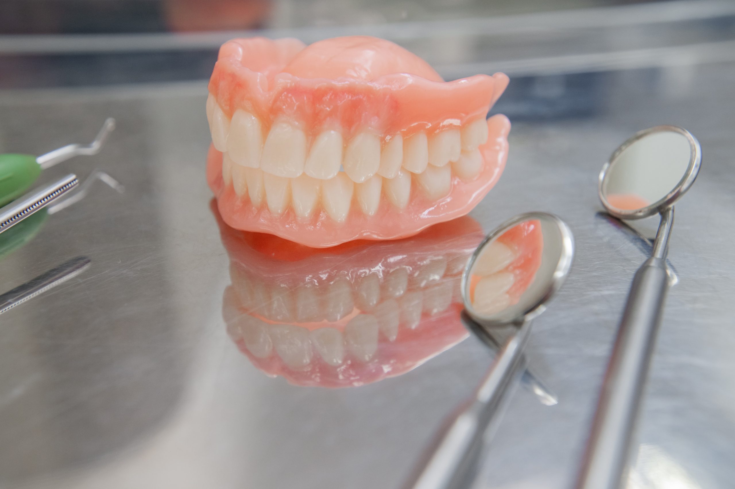 Set of dentures and dental tools. Close up Teeth and dental mirror. Diagnosis and copayment